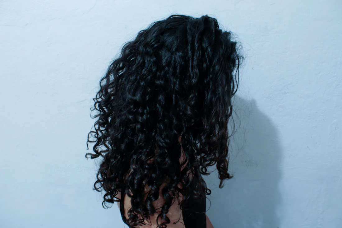 Avant : cheveux frisés et volumineux